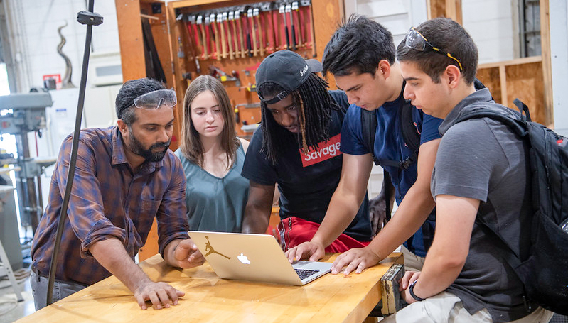 students working in a lab with a professor.